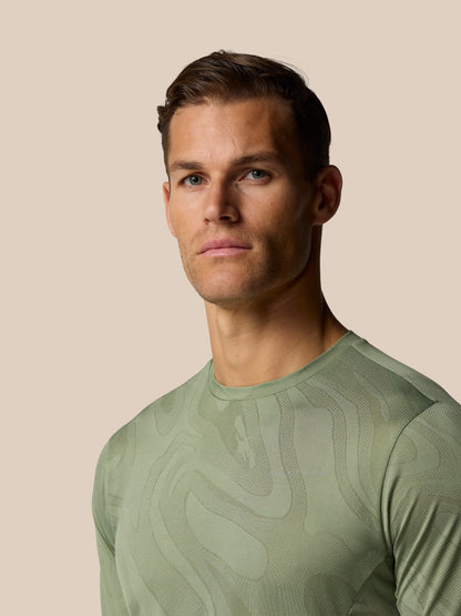 Close up of a male model wearing Zone Training LVS Long Sleeve Top in Thyme with a subtle all over pattern