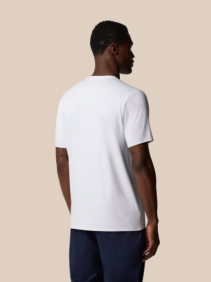 Back view of male model in a white Elevated Lifestyle T‑Shirt against a beige backdrop.