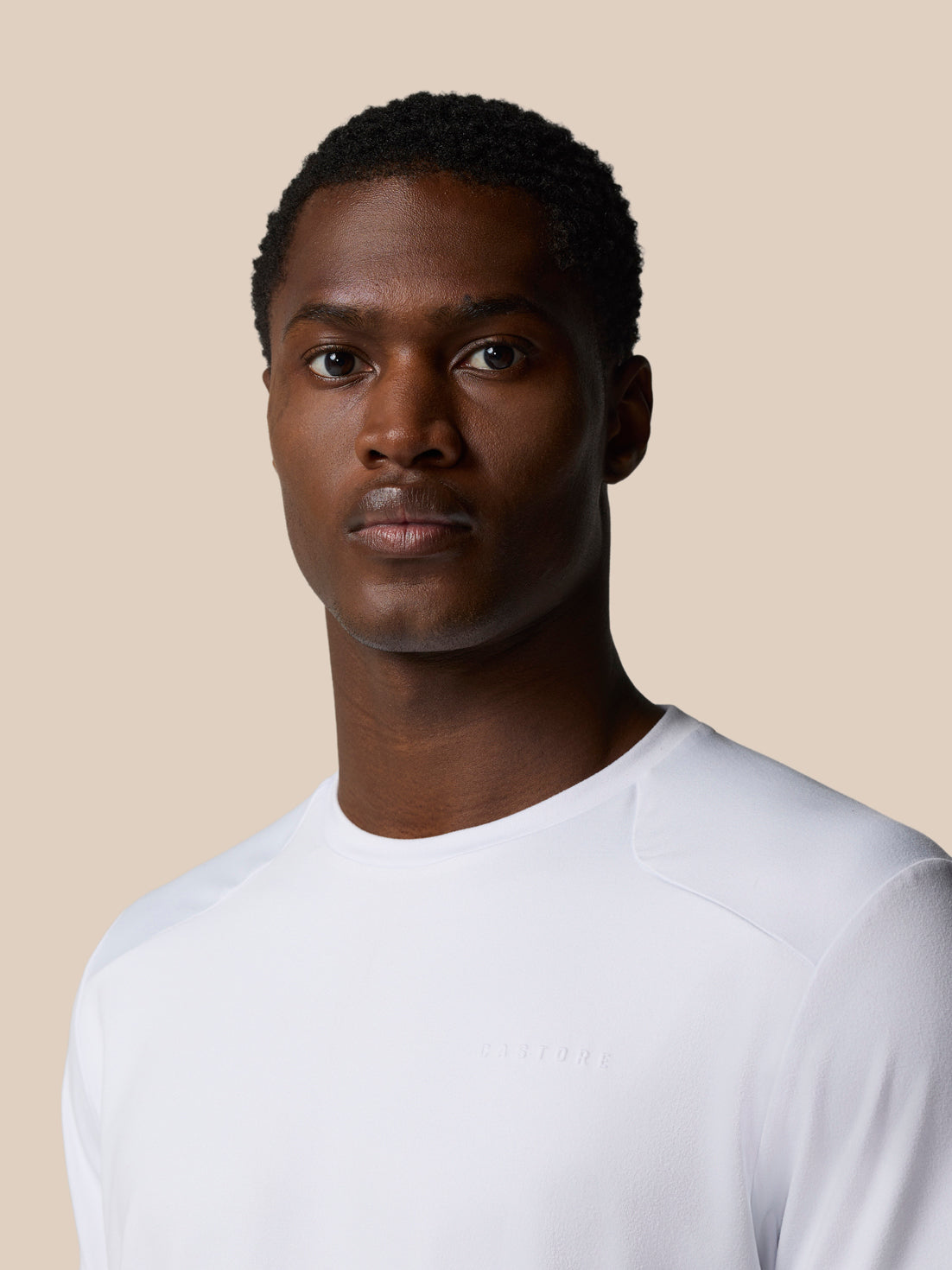 Back neck tape detail on white Elevated Lifestyle T Shirt worn by model.