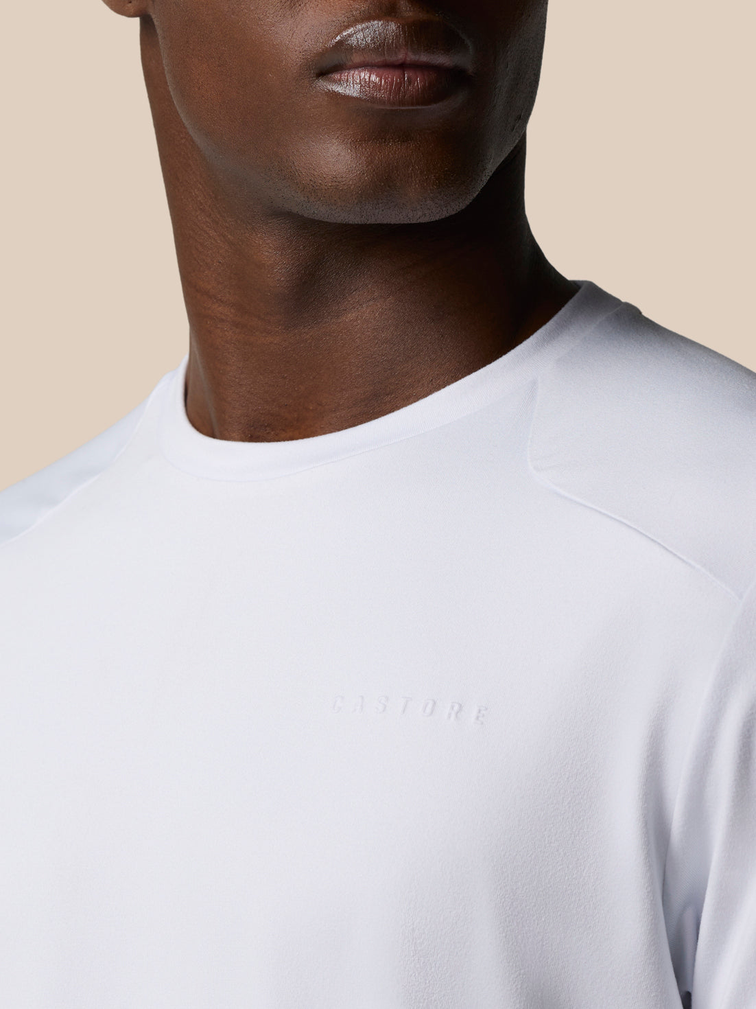 Close-up of white Elevated Lifestyle T-Shirt neckline with subtle embossed Castore logo on chest.
