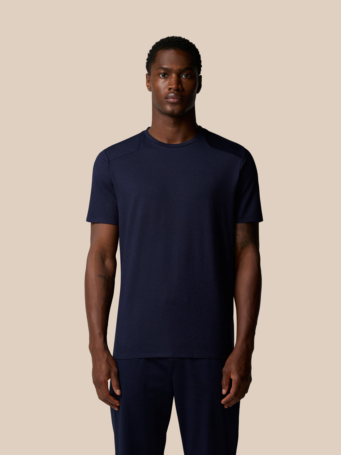 Front view of a man wearing navy Elevated Lifestyle T Shirt with clean knit fabric and Castore branding