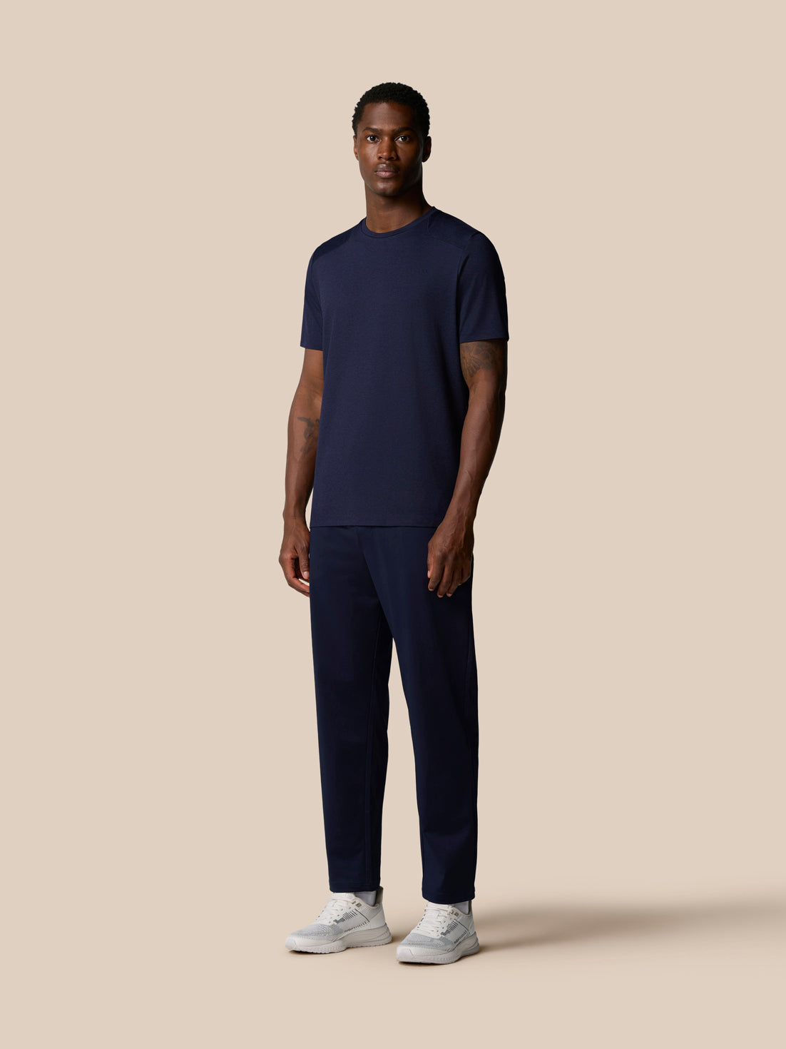 Full body front view of man wearing navy Elevated Lifestyle T Shirt.