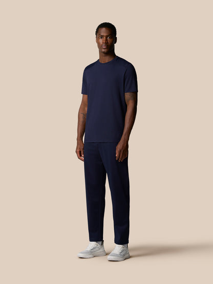Full body front view of man wearing navy Elevated Lifestyle T Shirt.