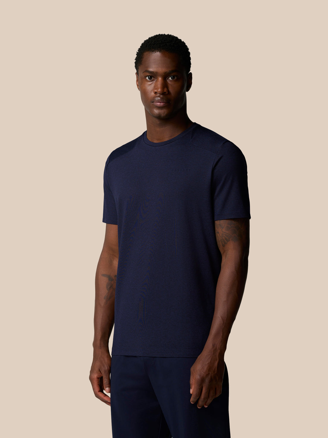 Angled front view of man in navy Elevated Lifestyle T Shirt.