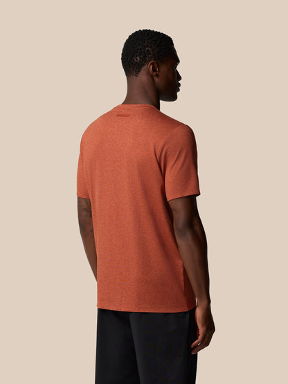 Back view of rust elevated lifestyle T shirt on a male model, showing Castore badge at upper back