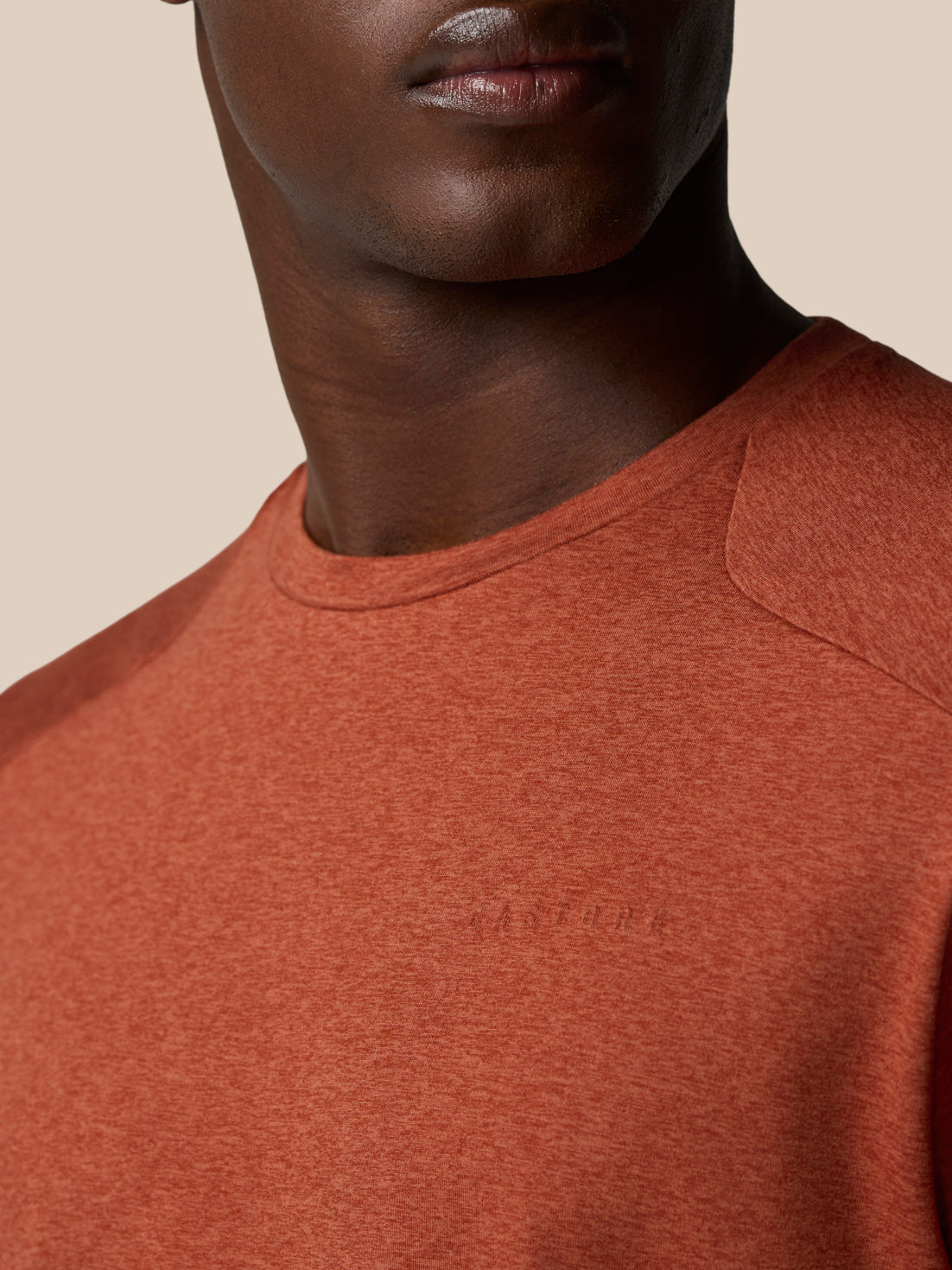 Close up of dark rust Elevated Lifestyle T Shirt neckline with a subtle Castore wordmark on the chest
