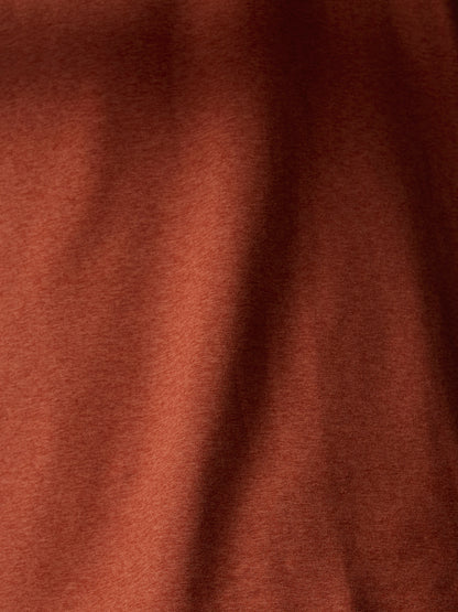 Close up of rust knit fabric around the back neck showing seam detail