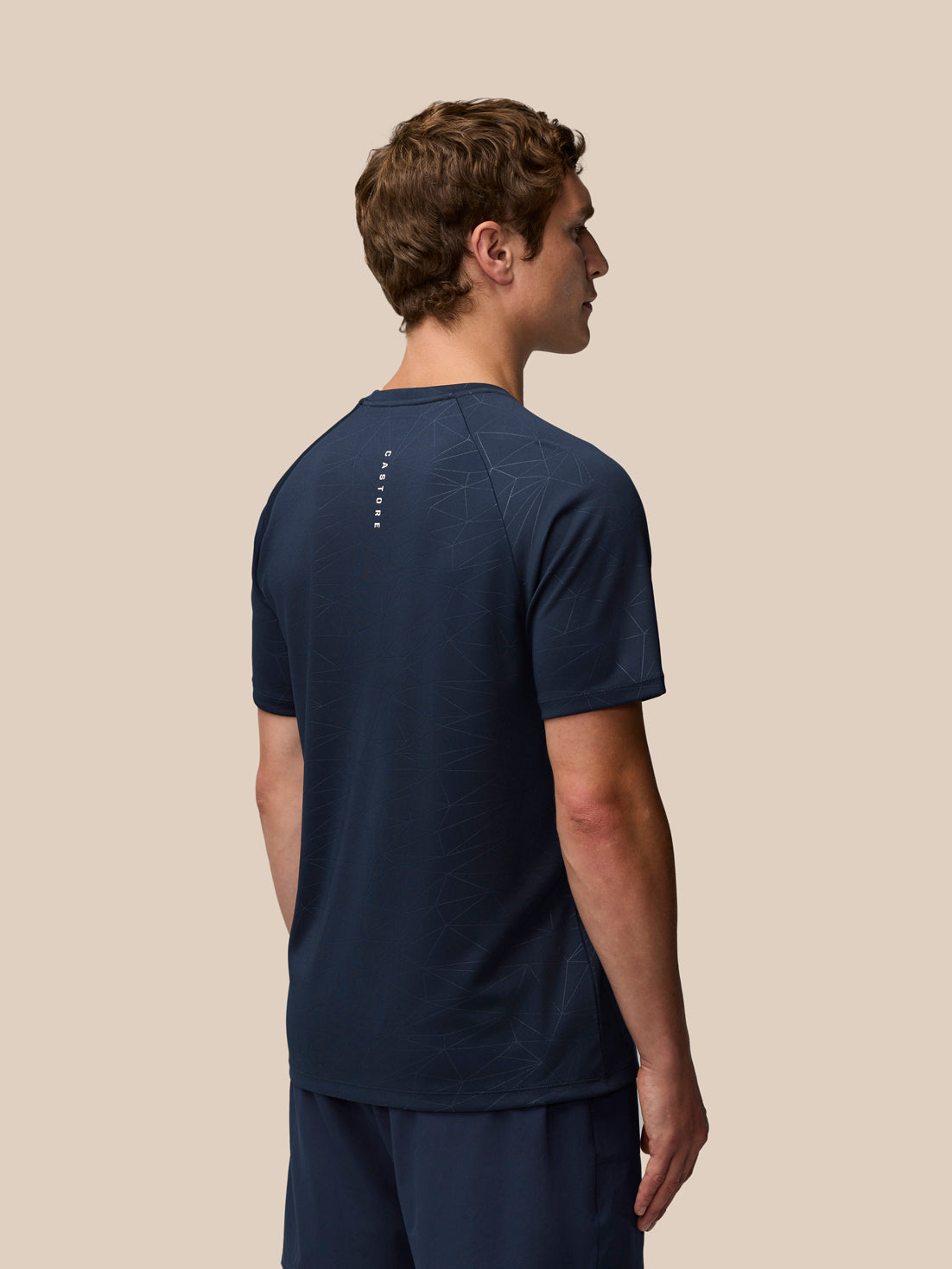Back view of navy Adapt Training T-Shirt showing the subtle geometric print and Castore wordmark at the back neck