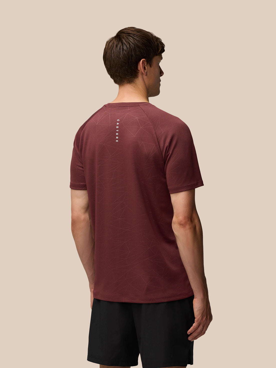 Back view of plum Adapt Training T-Shirt with allover geometric print and a vertical Castore wordmark down the center of the back