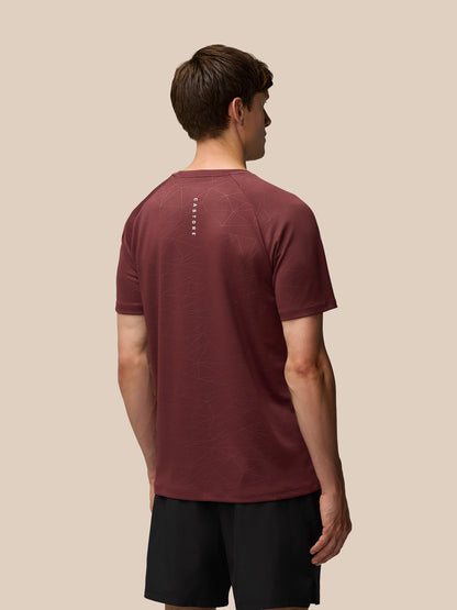 Back view of plum Adapt Training T-Shirt with allover geometric print and a vertical Castore wordmark down the center of the back