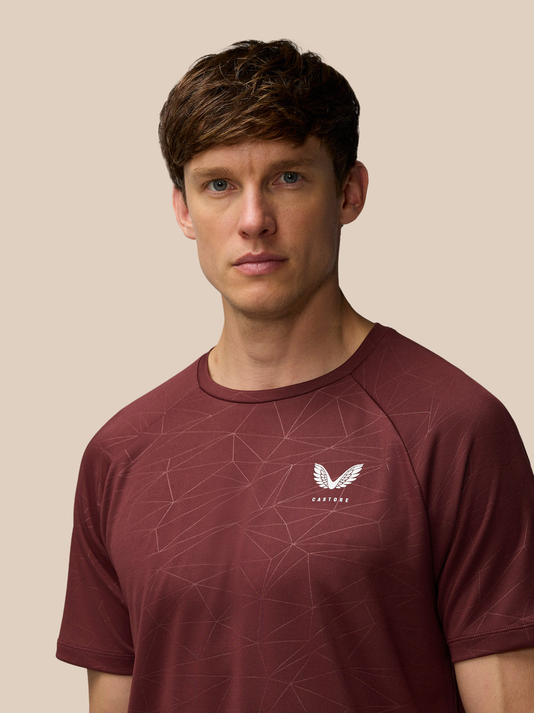 Model wearing plum Adapt Training T-Shirt with all over geometric print and Castore logo on left chest