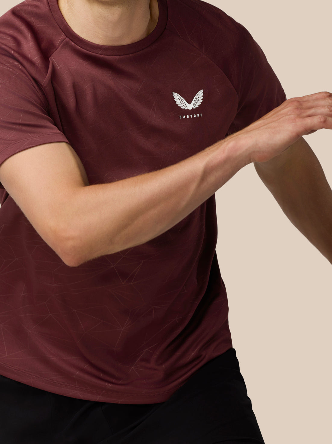 Front view of a man wearing the plum Adapt Training T-Shirt with a white Castore logo on the left chest and subtle geometric print