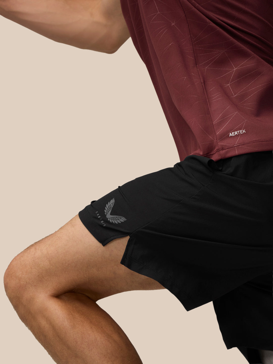 Back view of model wearing plum Adapt Training T-Shirt with all over print and vertical Castore wordmark down the back