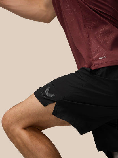 Back view of model wearing plum Adapt Training T-Shirt with all over print and vertical Castore wordmark down the back