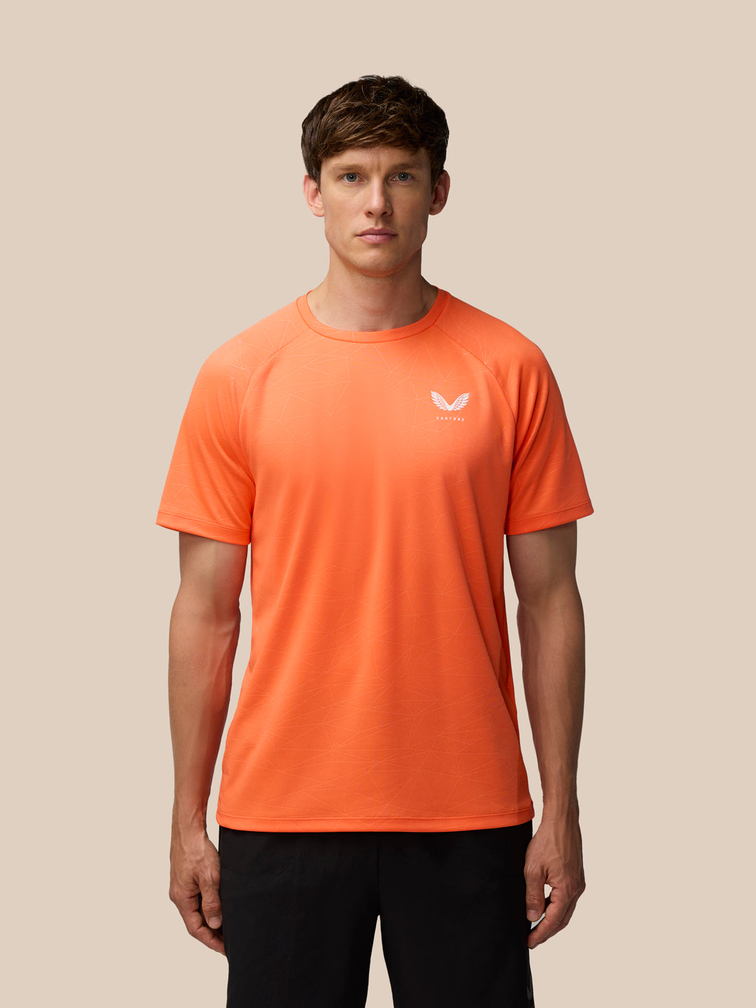 Male model in orange Adapt Training T Shirt with short sleeves and subtle geometric print and Castore logo on chest