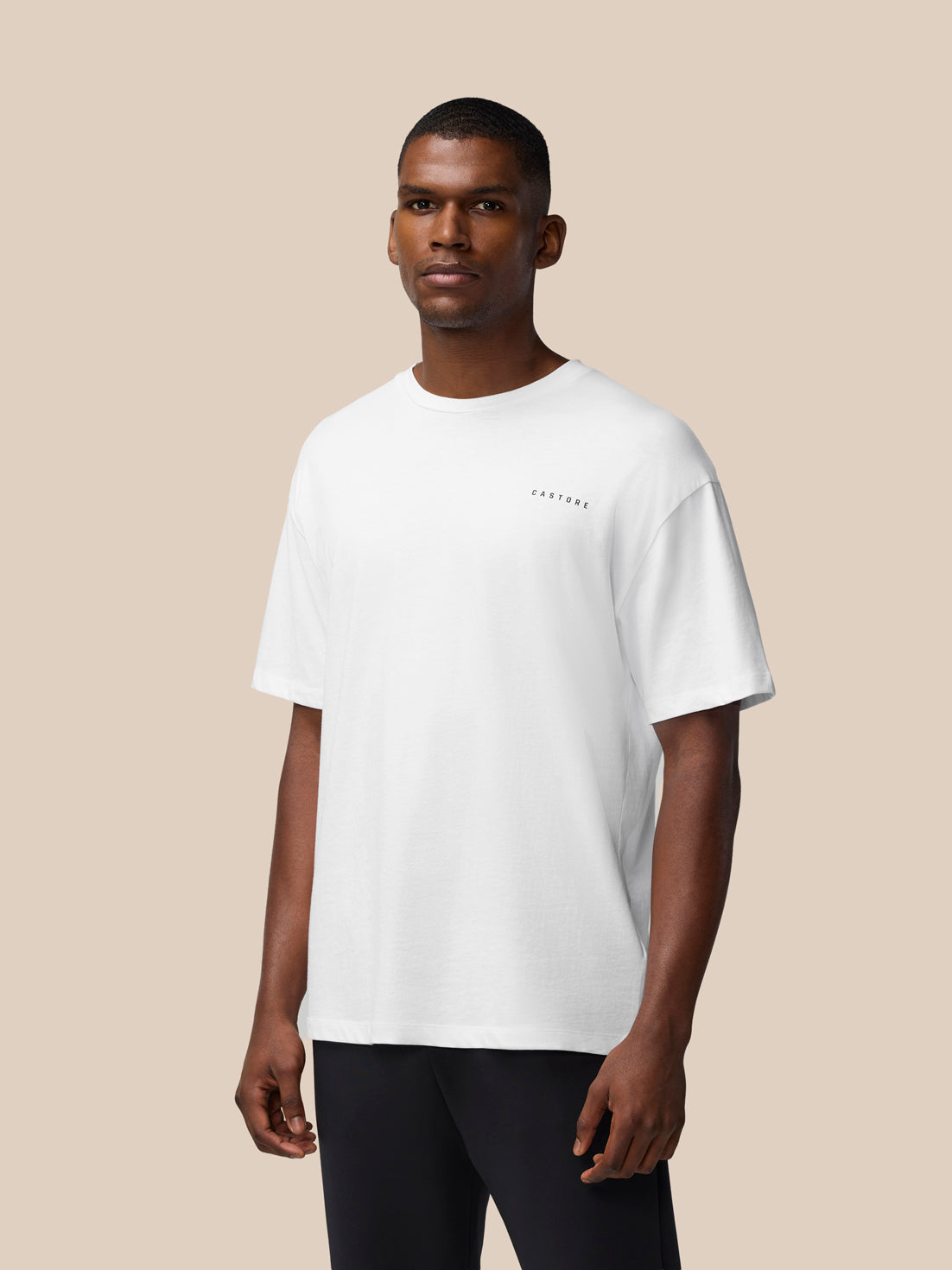 Male model wearing a white oversized short sleeve T shirt with a small Castore logo on the chest