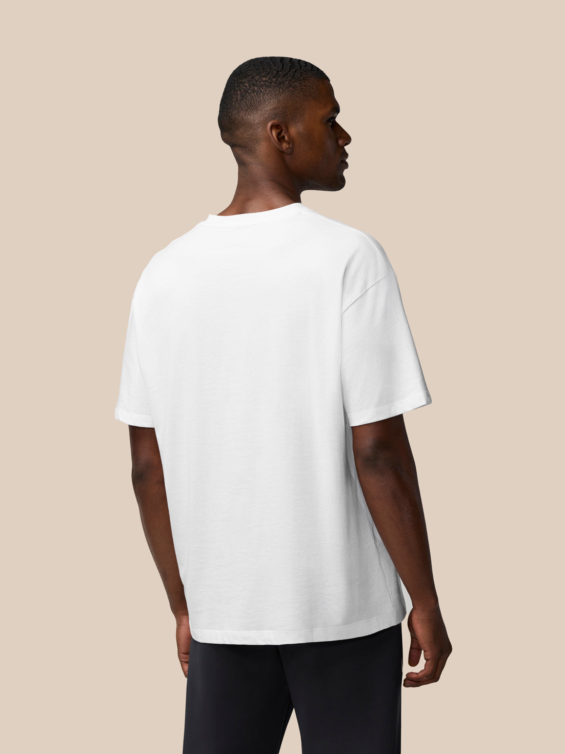 Back view of a male model wearing a white oversized T shirt