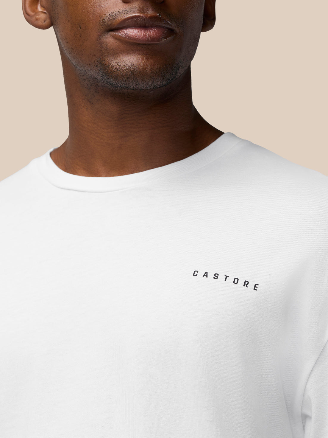 Close up of white T shirt showing CASTORE logo near the chest and crew neck