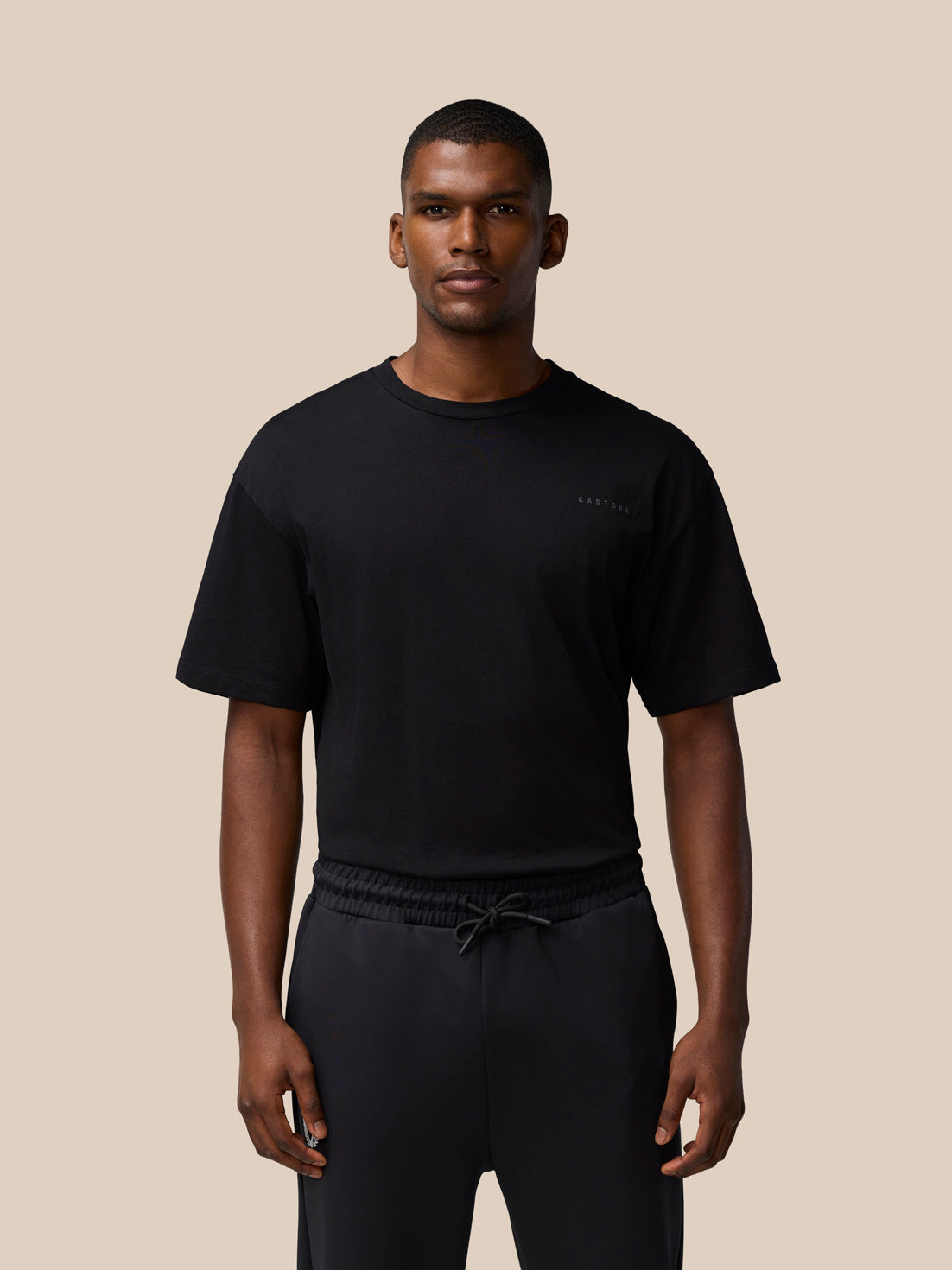 Full torso shot of a male model wearing a black Flex Cotton T Shirt with a round neckline and a small chest logo.