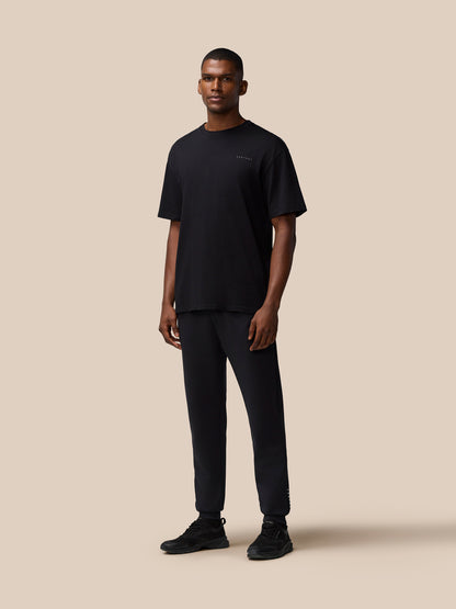 Full body of a male model wearing black Flex Cotton T-Shirt and matching joggers