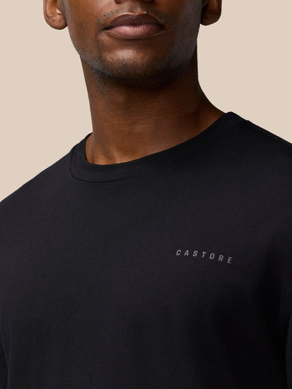 Close-up of a black Castore Flex Cotton T-Shirt worn by a model, showing round neckline and chest logo.