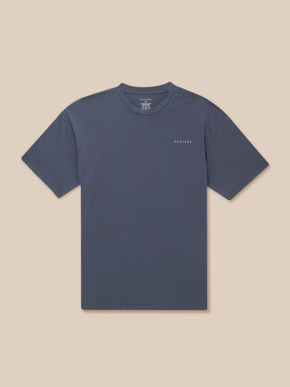 Upper body shot of a pewter blue Flex Cotton T Shirt with a round neckline and a Castore logo on the chest.