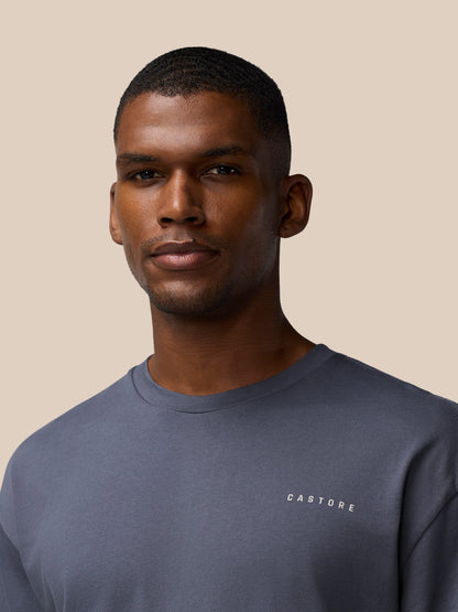 Male model wearing pewter gray Flex Cotton T-shirt with round neckline and Castore logo.