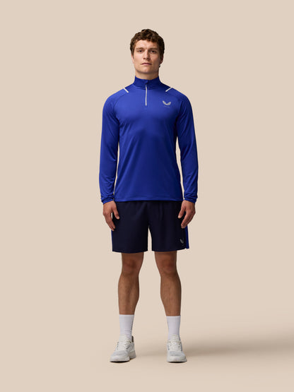 Male model wearing blue Apex Training Winterised 1/4 Zip Top with high collar white shoulder accents and chest logo