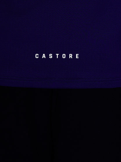 Close-up of blue athletic top fabric with Castore branding and stitched hem seam
