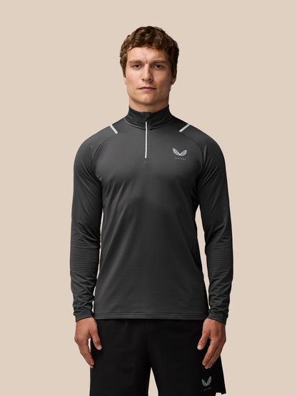 Male model wearing charcoal Apex Thermal Winterised 1/4 Zip Top with chest logo