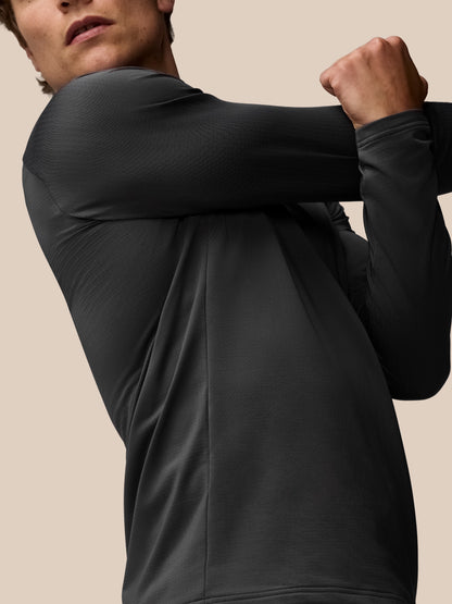 Model wearing charcoal Apex Training Winterised ¼ zip top, close up on textured grid fleece and raglan sleeves
