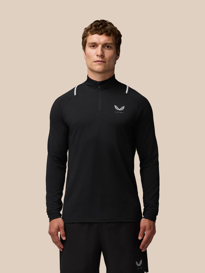 Front view of a man in a black Apex Training quarter zip top with reflective shoulder accents