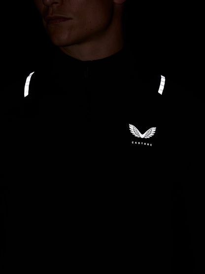 Close up of black Apex Quarter Zip top featuring white reflective shoulder stripes and Castore chest logo