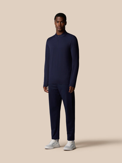 Full body shot of a male model wearing navy Elevated Lifestyle top with matching navy pants and white sneakers