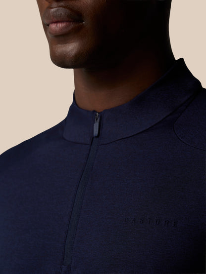 Close-up of navy Elevated Lifestyle quarter-zip top showing center front zip and left chest Castore logo