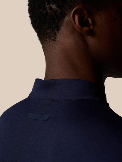 Back view of navy quarter-zip top highlighting back neck tape and Castore badge identifier at upper back