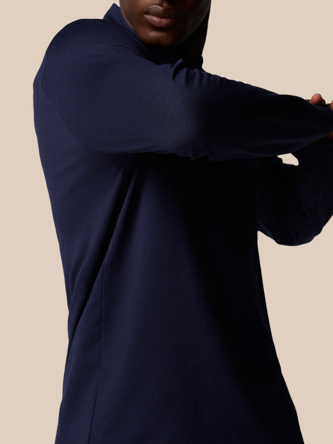 Back view of navy quarter-zip top with Castore wordmark badge visible on the upper back