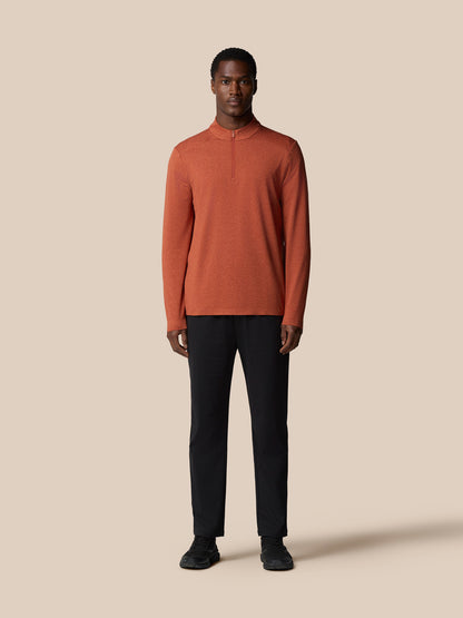 Rear three quarter view of dark rust elevated lifestyle quarter zip top on a male model