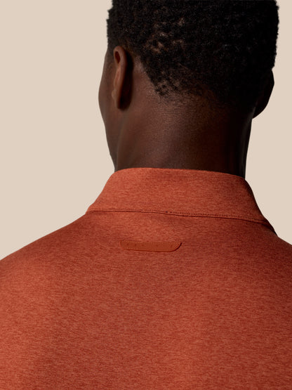 Back view of the rust colored 1/4 Zip Top showing collar seam and a small Castore badge on the upper back