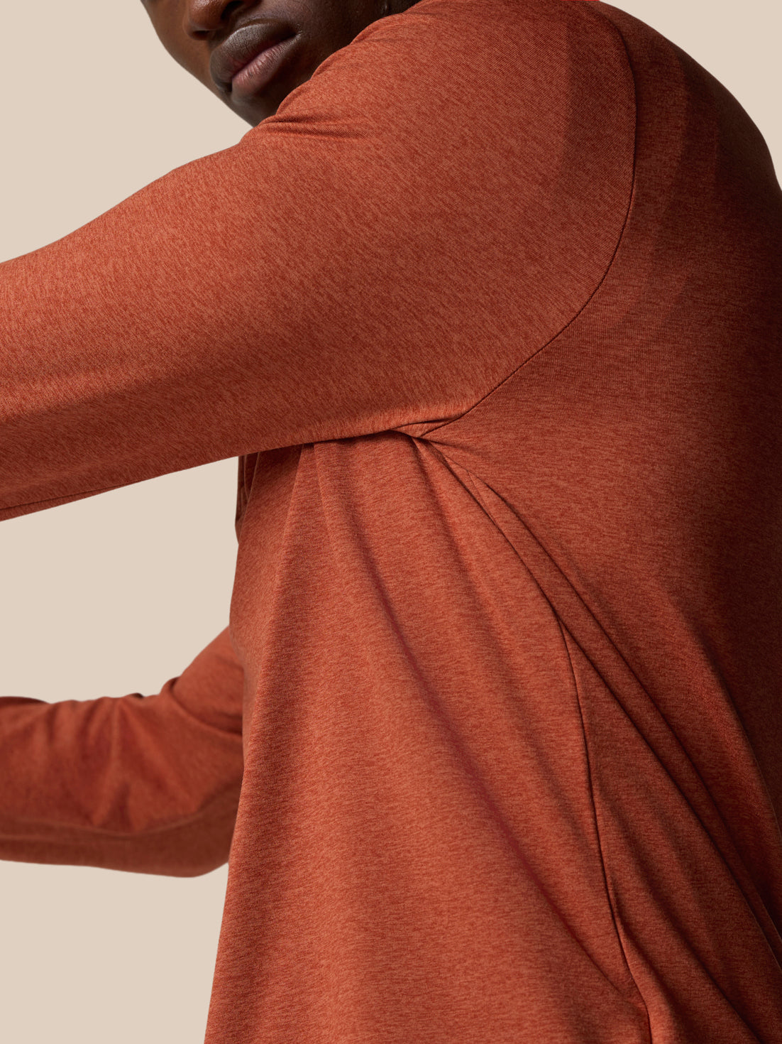 Close-up of dark rust knit fabric on the shoulder and upper back of the Elevated Lifestyle quarter zip top