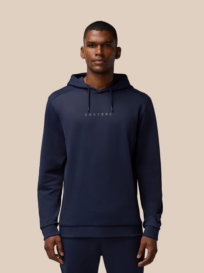 Male model wearing navy Flex Lifestyle Thermo Hoodie featuring Castore wordmark at center chest and logo on left cuff