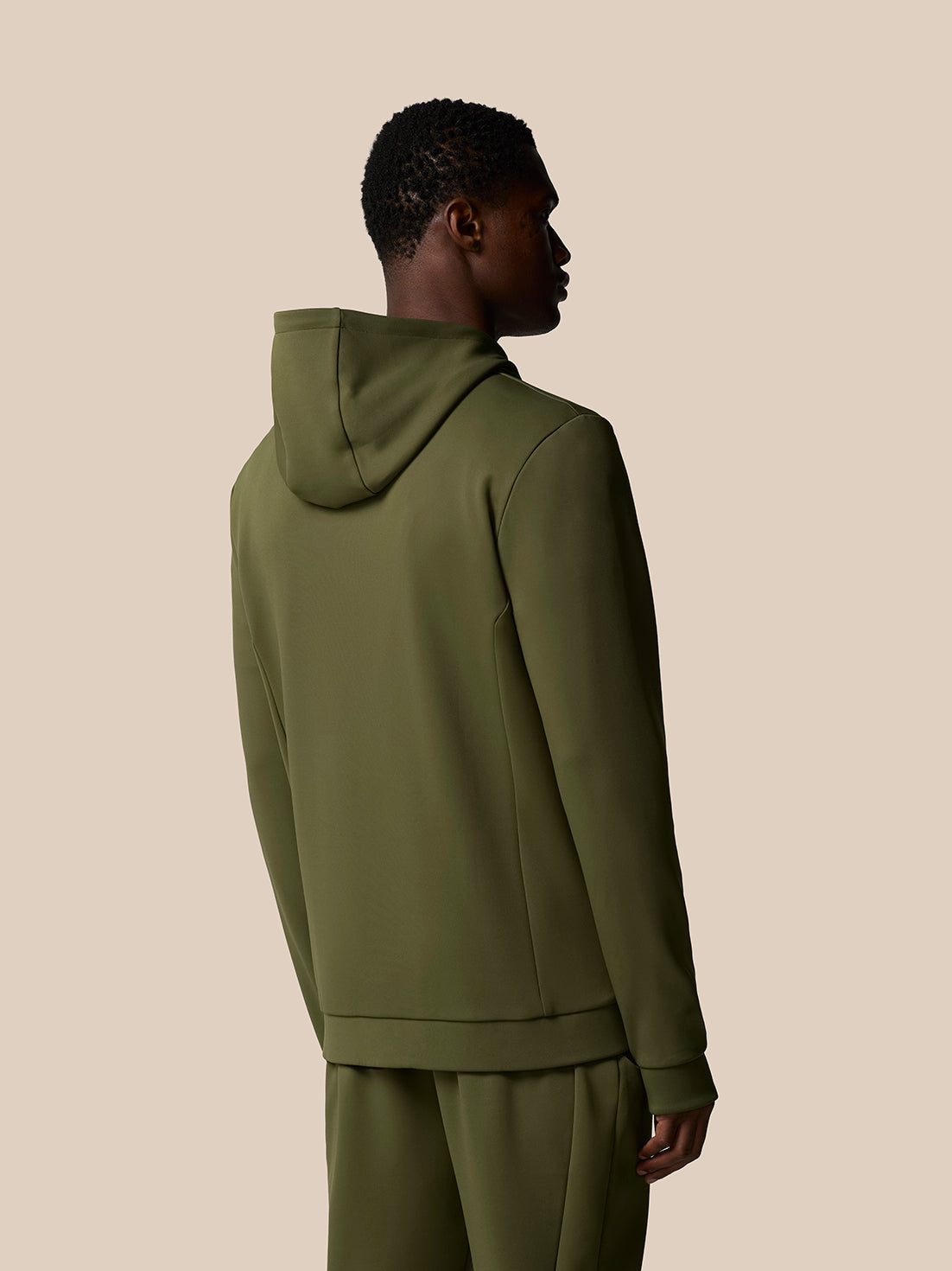 Back view of a male model wearing an olive green Flex Lifestyle Thermo Hoodie with the hood up
