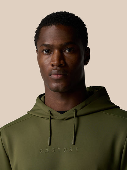Close-up of a male model in an olive green Castore hoodie with chest logo and drawstrings
