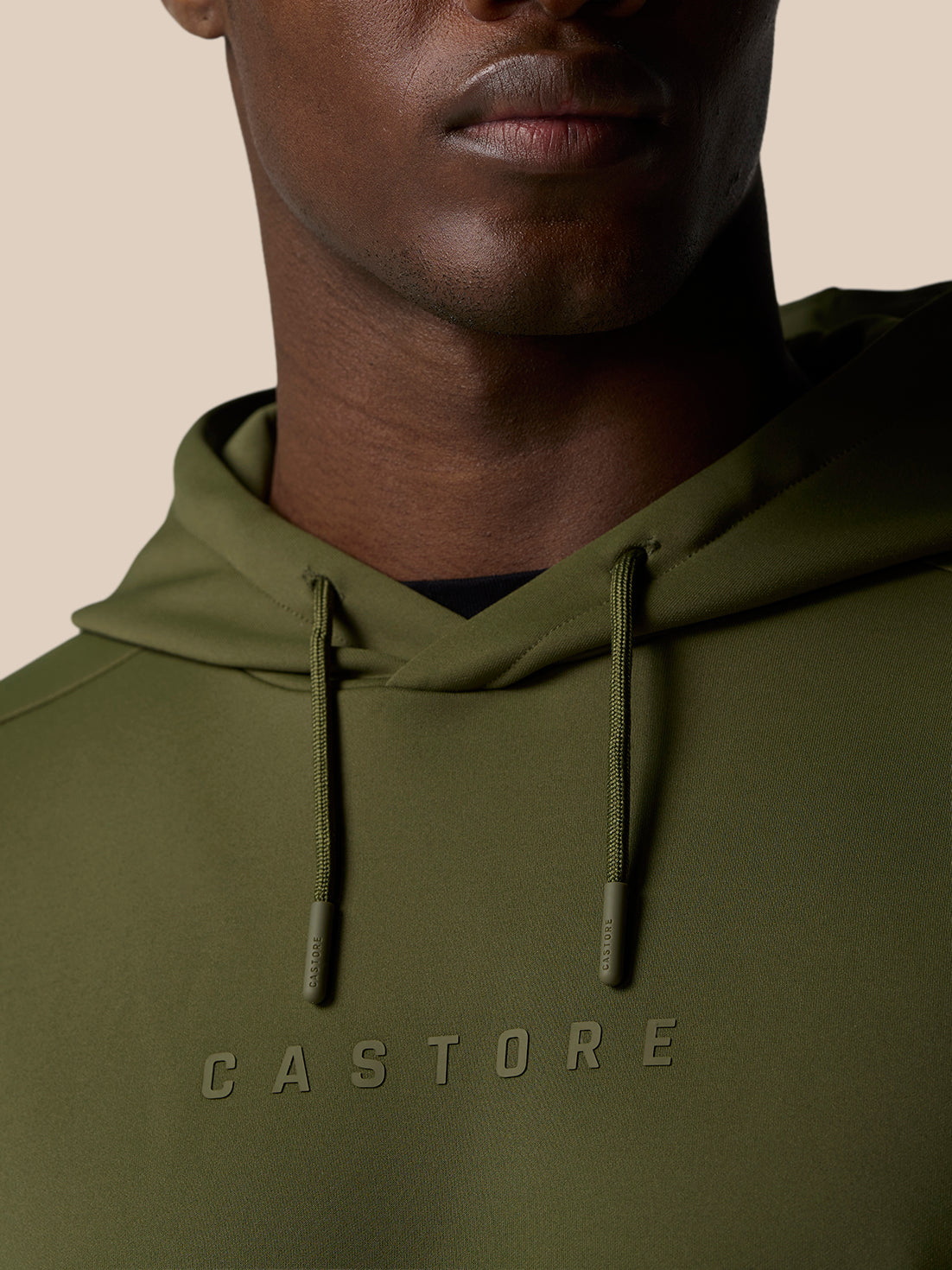Close-up of olive green Flex Lifestyle Thermo Hoodie showing hood with drawstrings and CASTORE wordmark across the chest