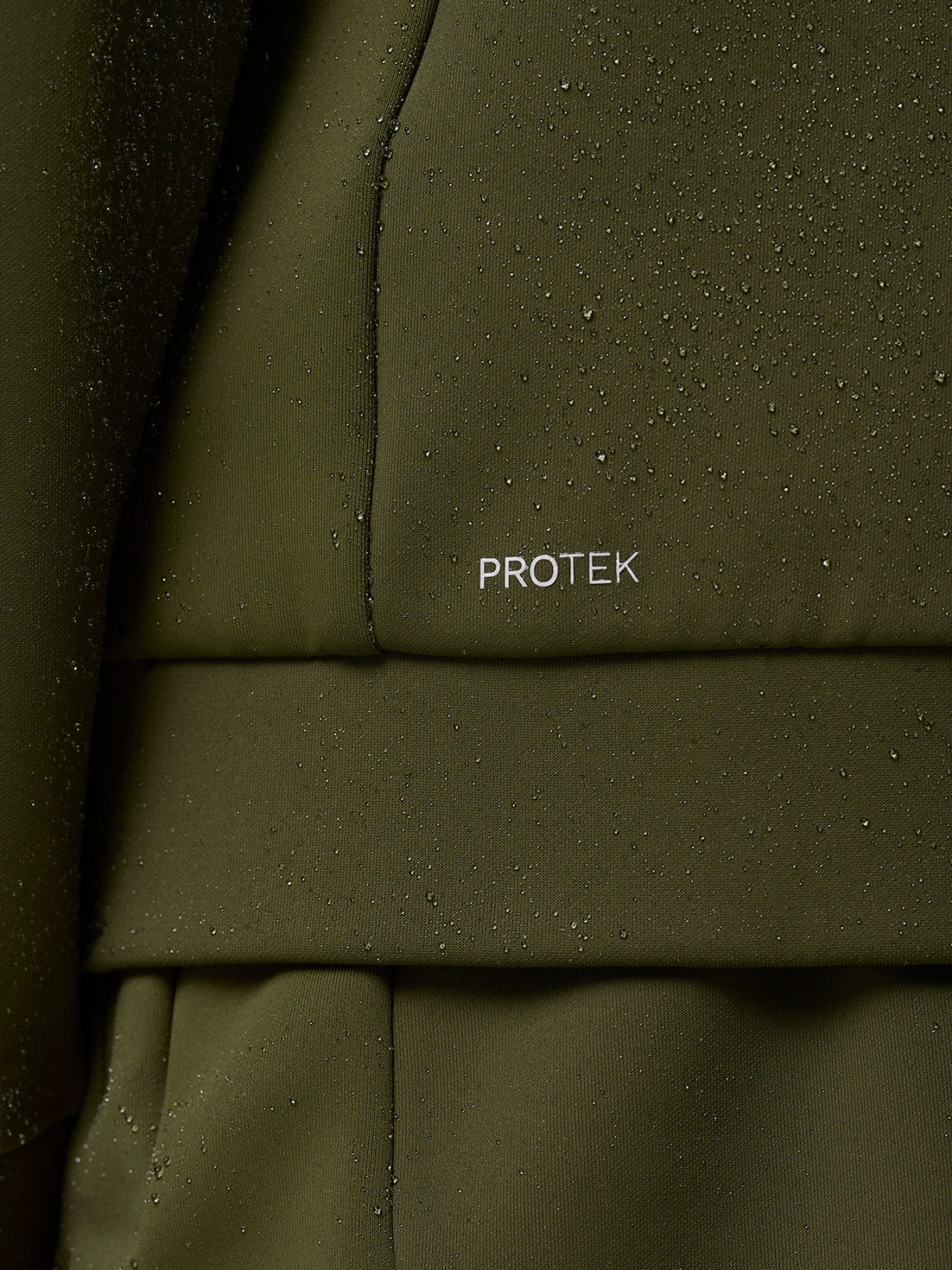 Close-up of olive green Flex Thermo Hoodie fabric with water droplets and ProTek logo