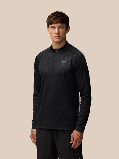 Model wearing black Adapt Training 1/4 Zip Top with geometric print and left chest Castore logo.