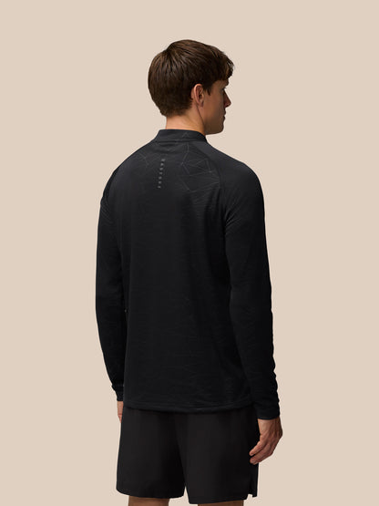 Back view of model in black Adapt Training top showing heat embossed all-over print and back neck Castore branding.