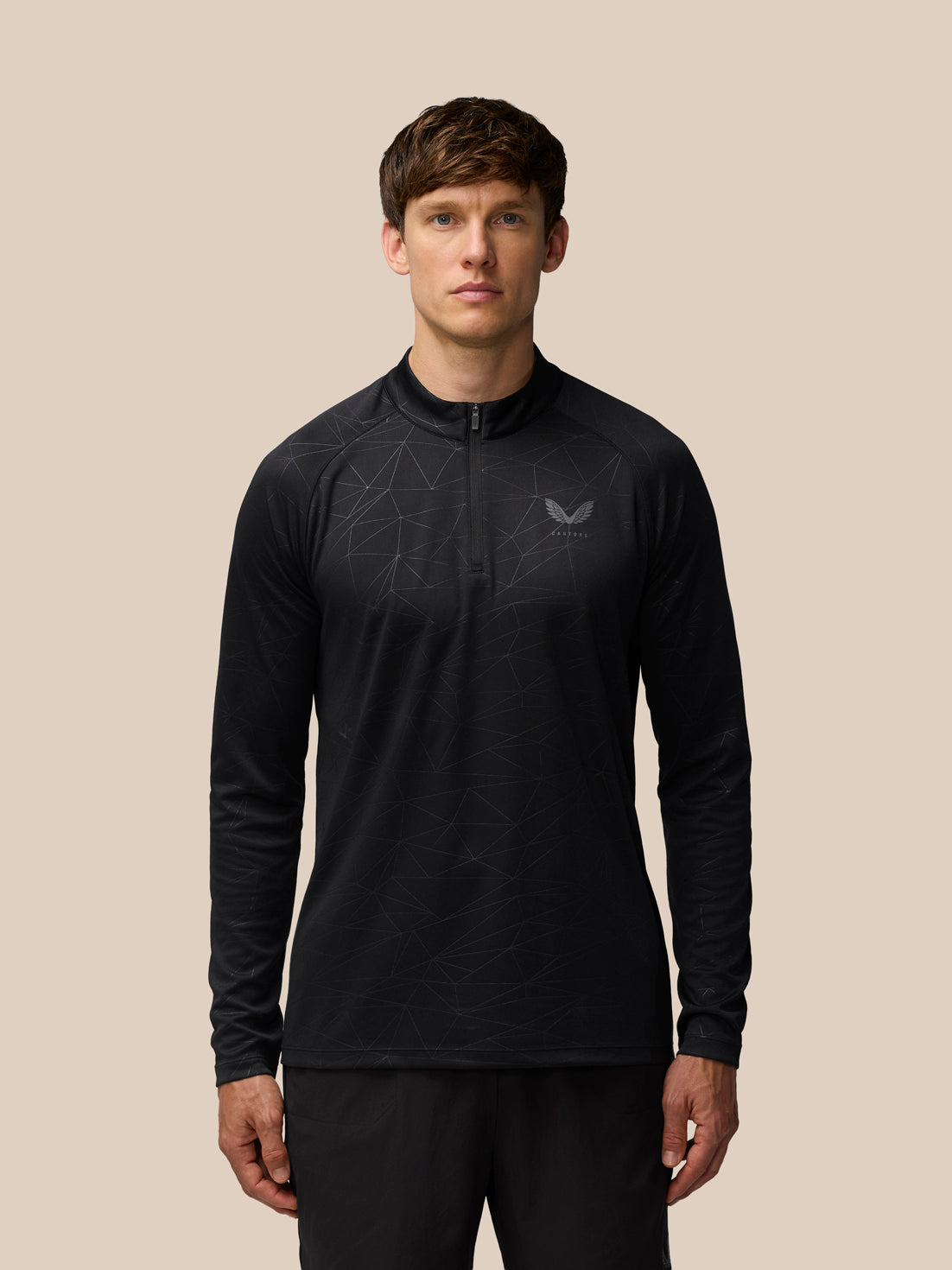 Male model wearing black Adapt Training 1/4 Zip Top with a subtle geometric all over print