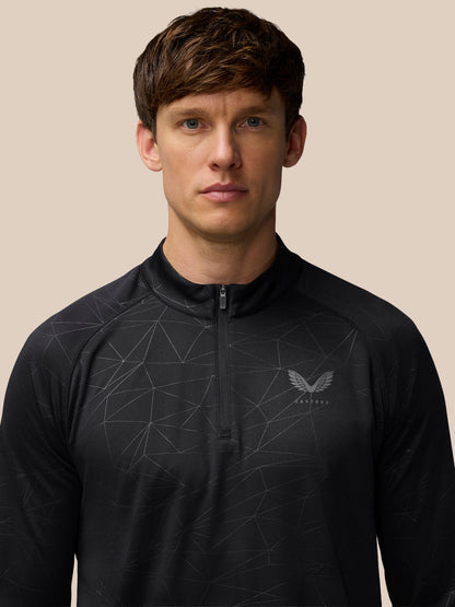 Front view of model wearing black Adapt Training 1/4 Zip Top with geometric print and center front zip