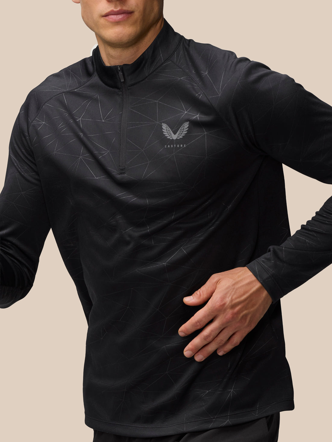 Man wearing black Adapt Training 1/4 Zip Top with all over geometric print and Castore logo on left chest